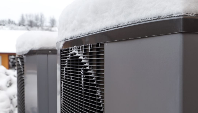 Heat pump outside covered in snow