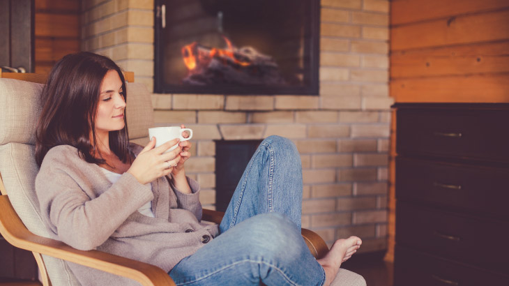 Women drinking tea next to fireplace